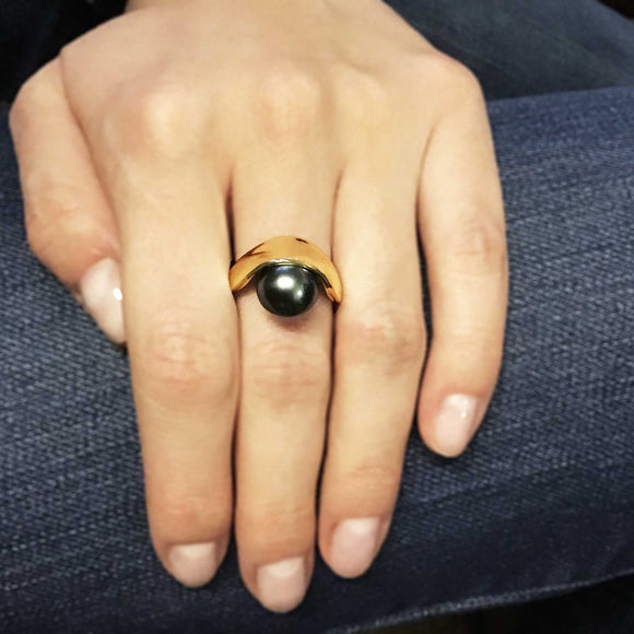 Sling Ring. A 12mm grey Tahitian pearl held in a yellow gold band