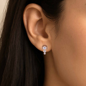 model wears 3 stone diamond and rose gold stud earrings