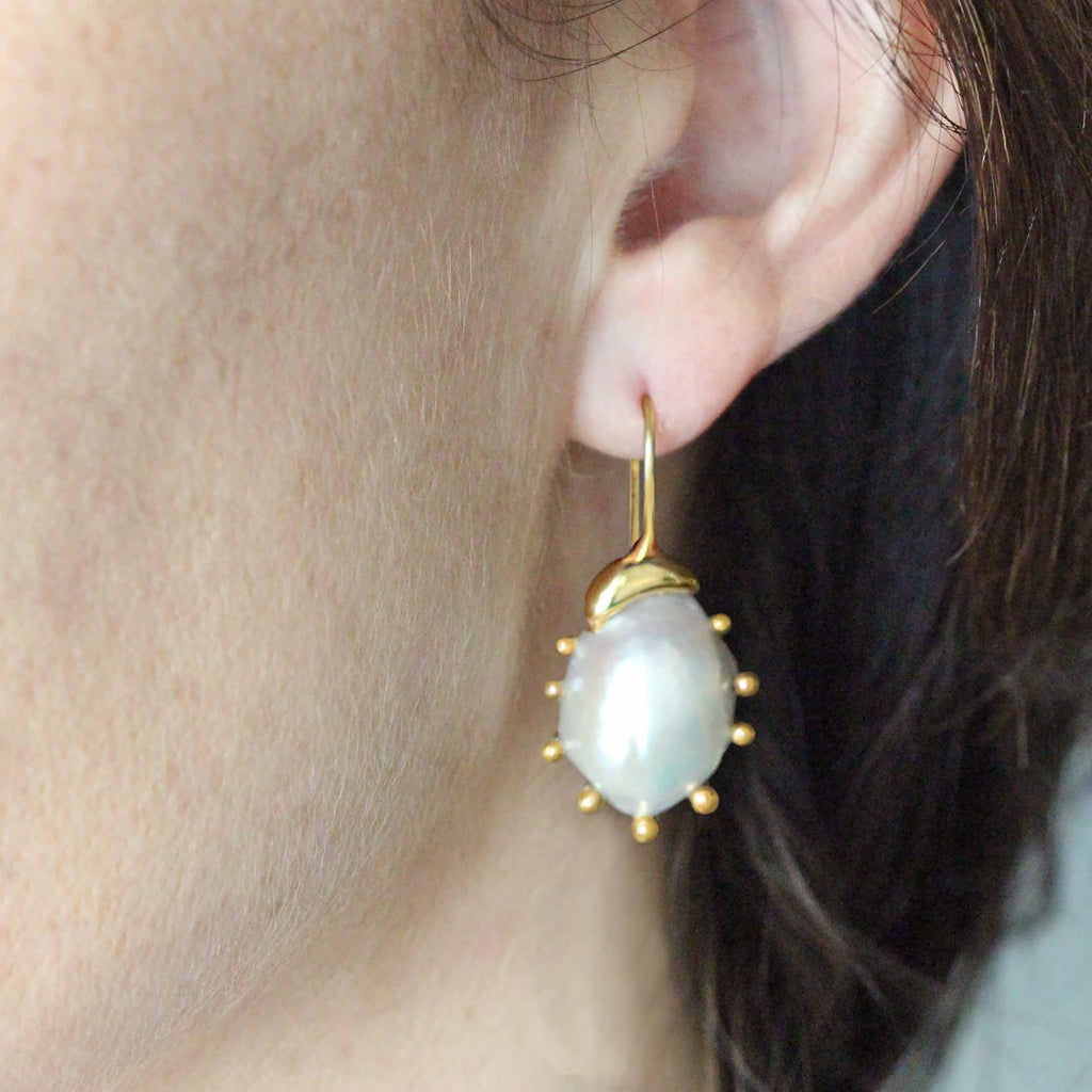 Mollusc baroque freshwater pearl and yellow gold earrings on model