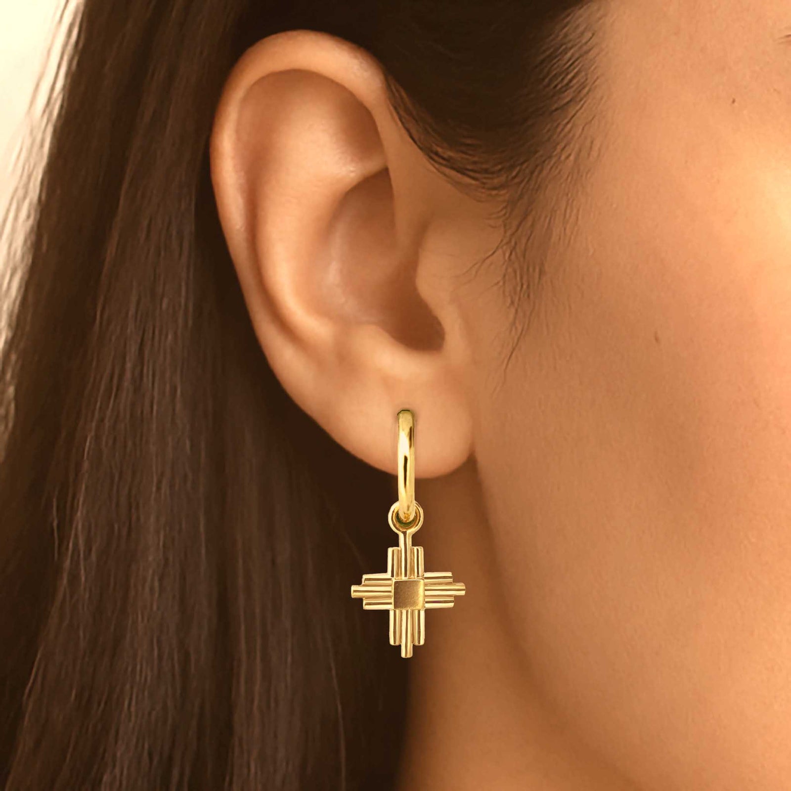 Rose gold earrings on a huggie.