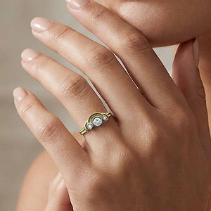 Gold ring with a diamond on a hand against a neutral background