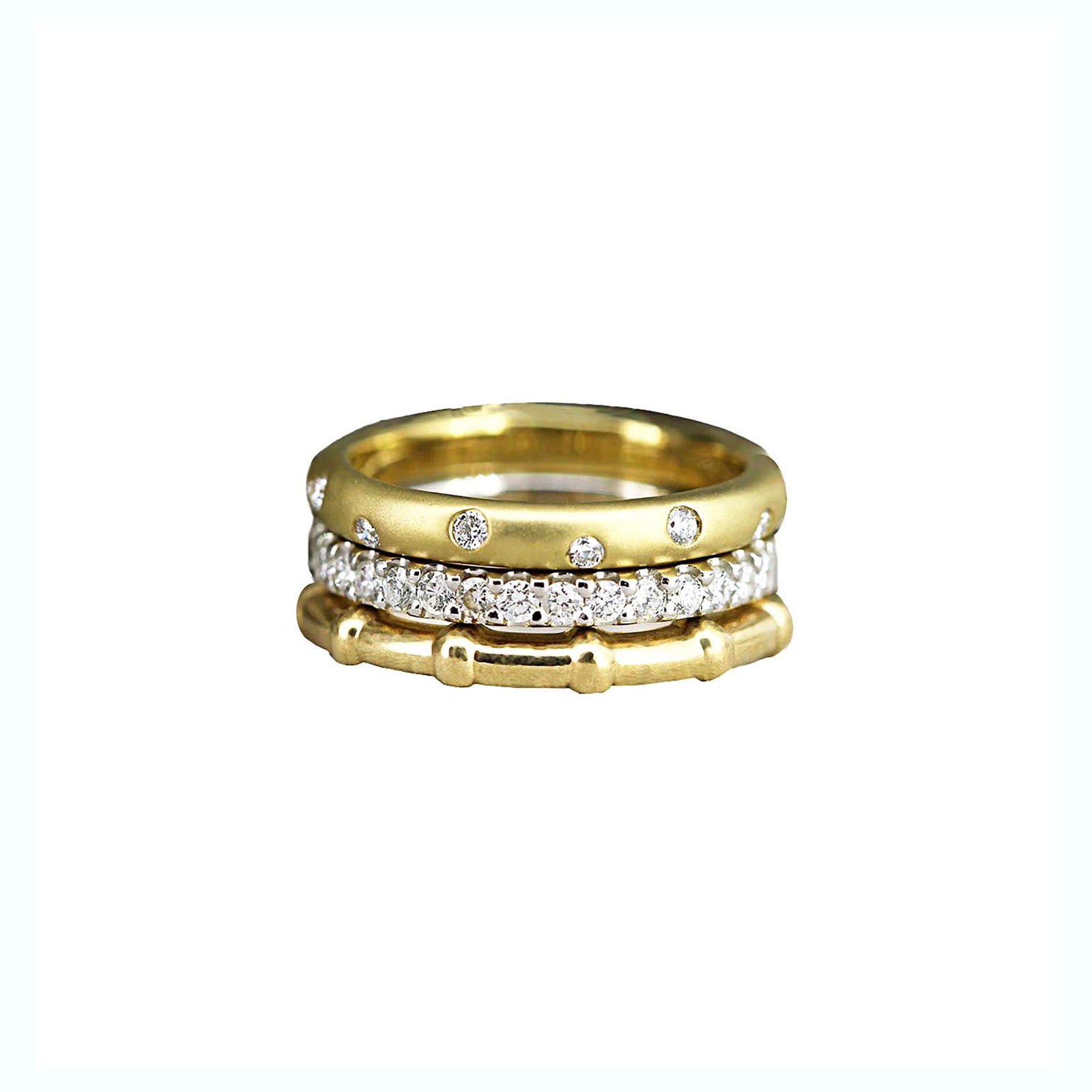 A stack of three diamond and gold ring on a white background