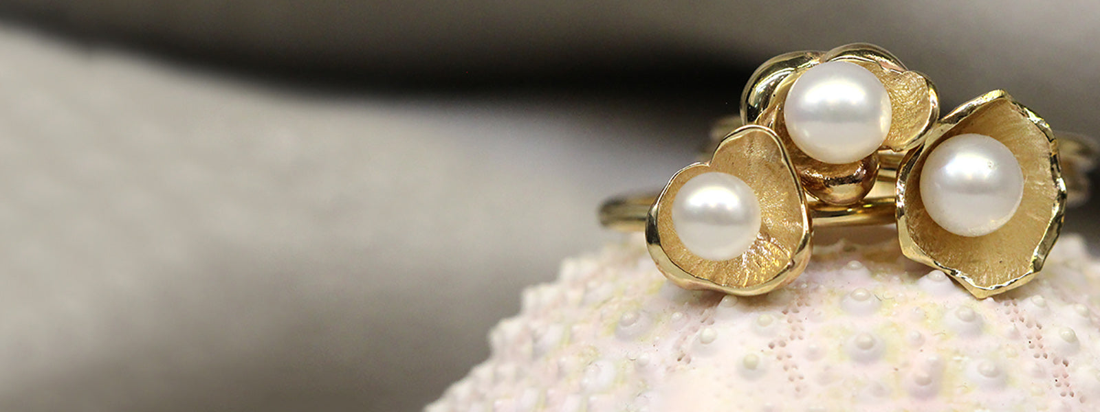Pearl and yellow gold ring stack on shell