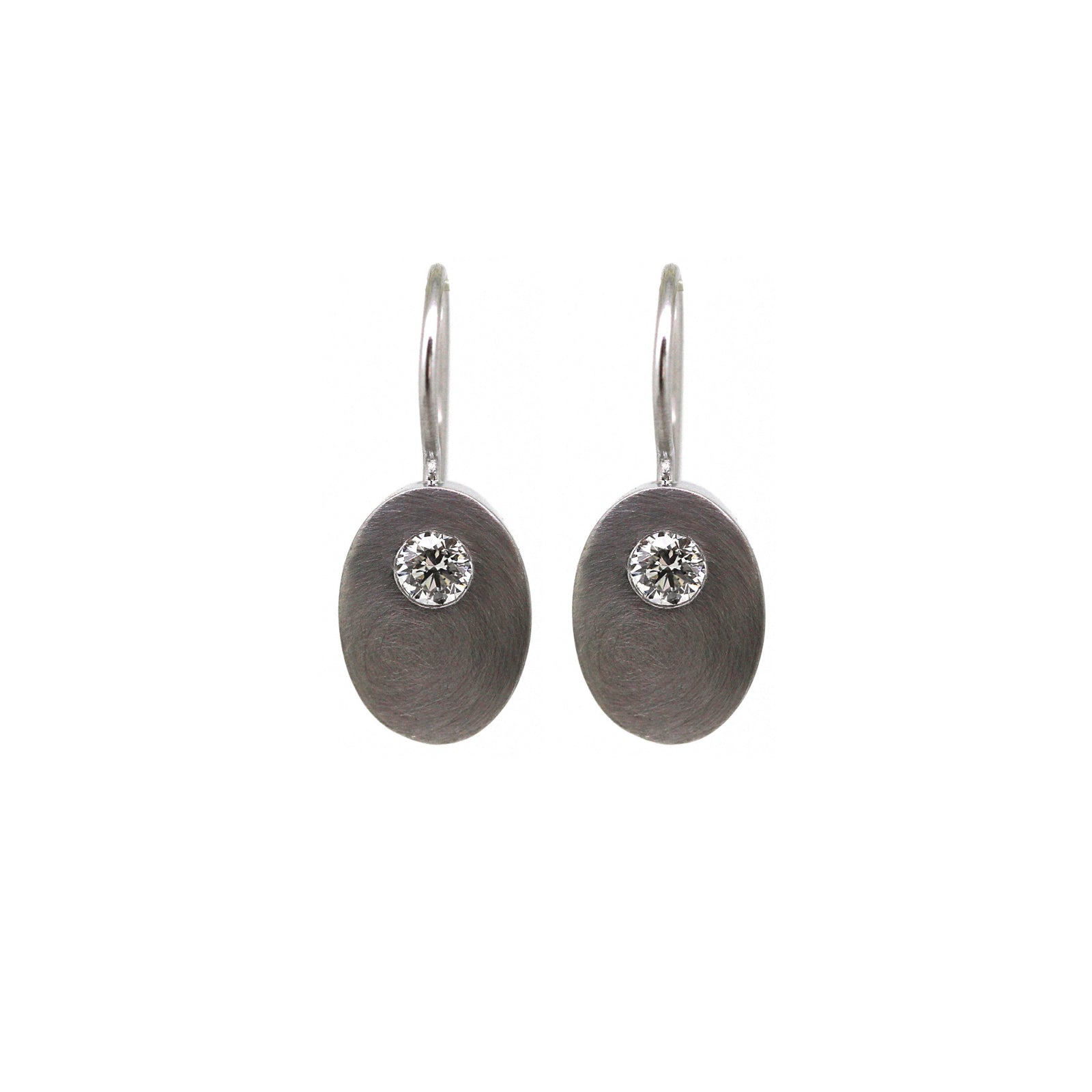 A pair of white gold elemental earrings with round shapes and adorned with diamonds.