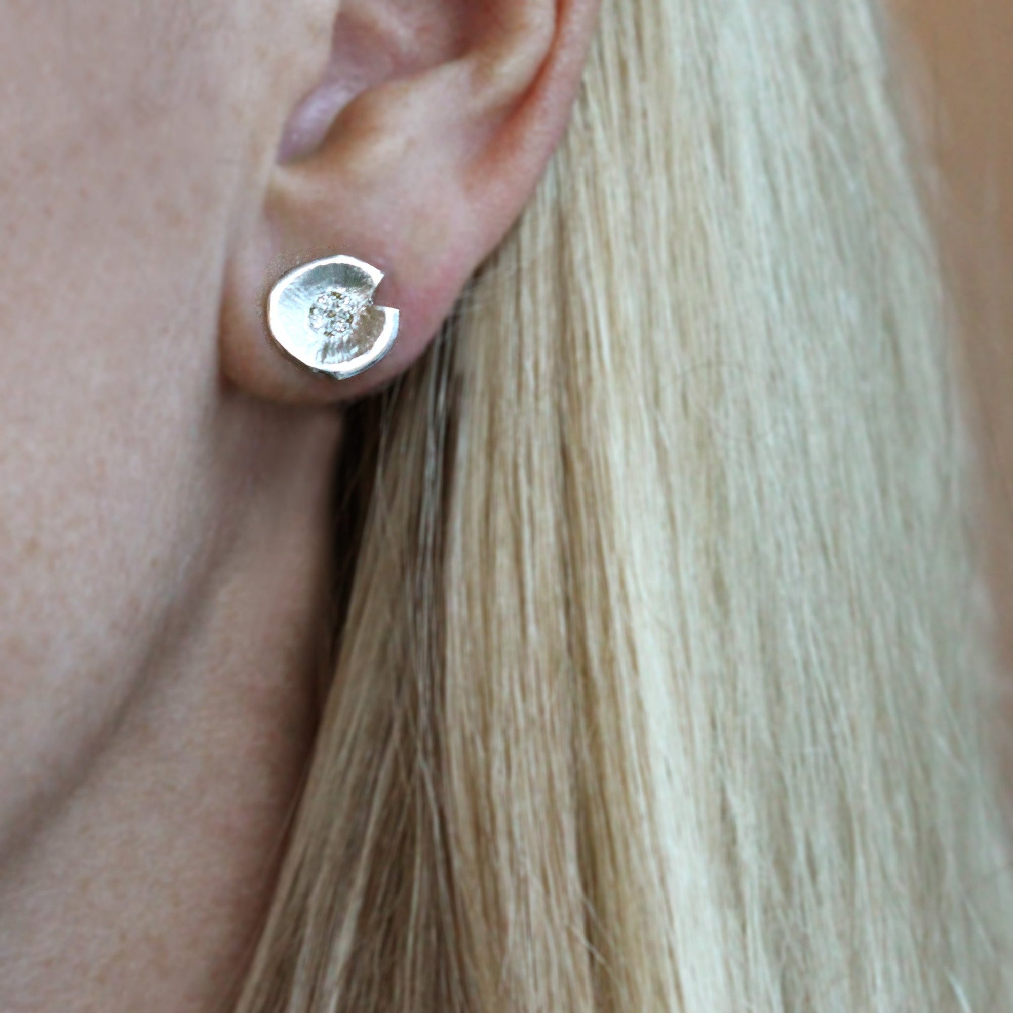 Lilypad diamond stud earrings with 8 pave set diamonds in white gold seen here on model