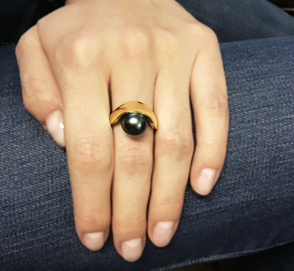 Sling Ring. A 12mm grey Tahitian pearl held in a yellow gold band
