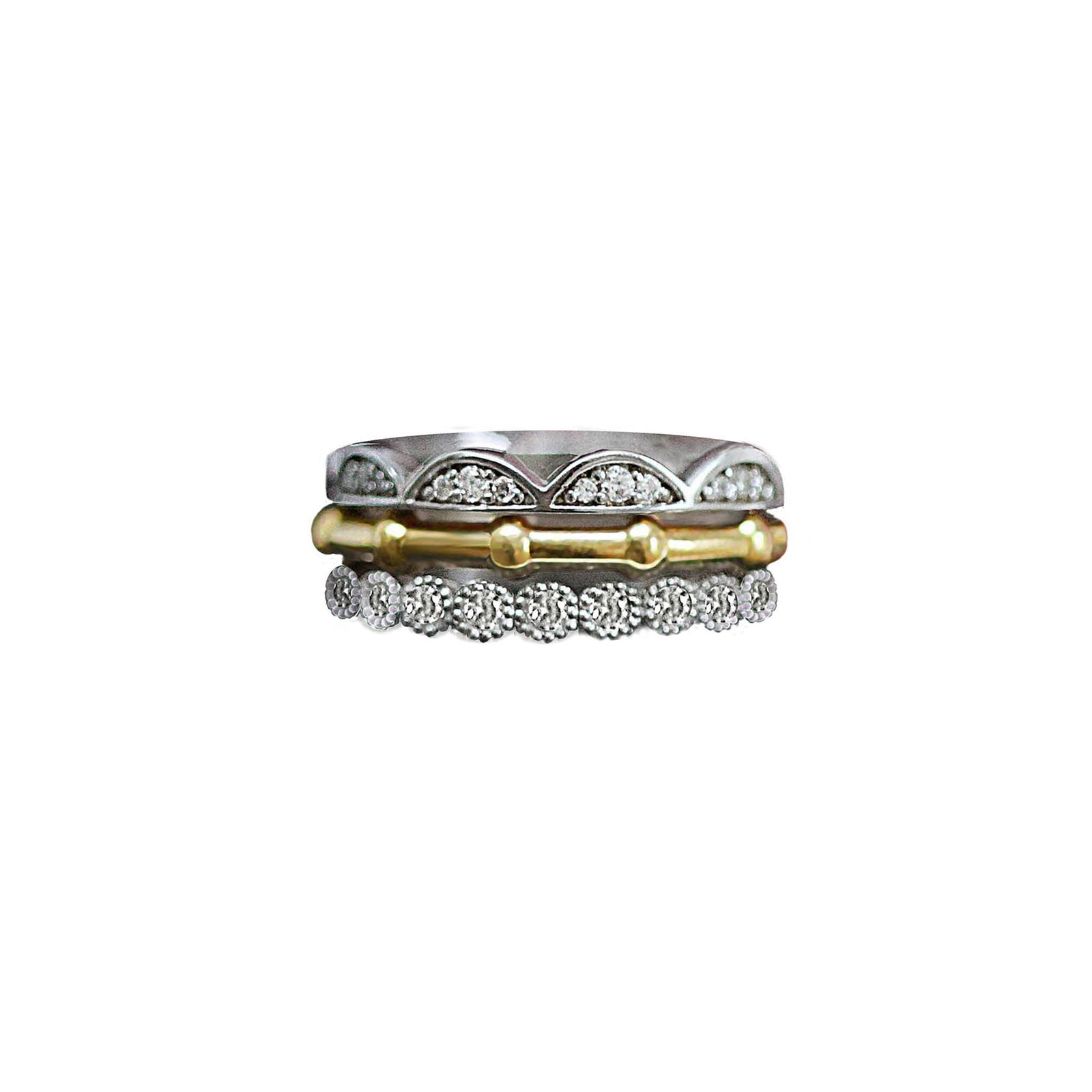 A stack of rings in white gold, yellow gold and diamonds. The Frill ring, the rib ring and the Blossom bud ring