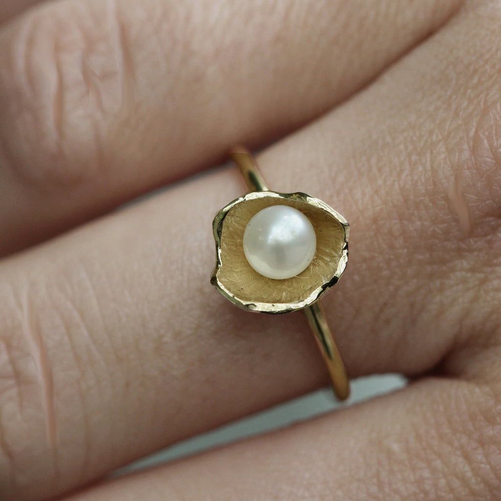 Large sunken treasure gold and pearl ring on hand