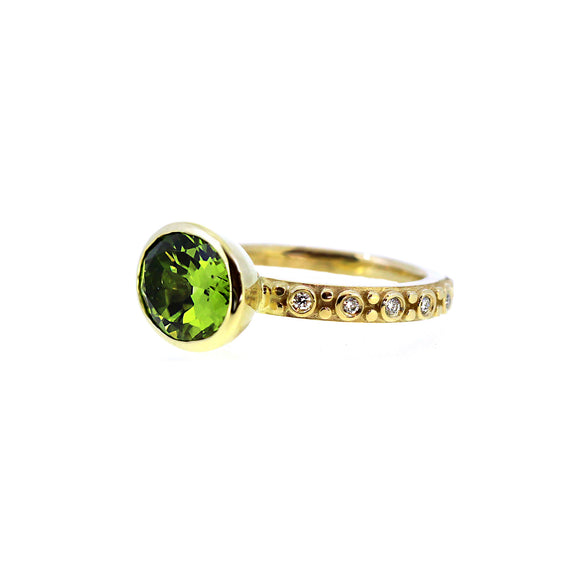Shimering green oval peridot set in diamond and yellow 14k gold band